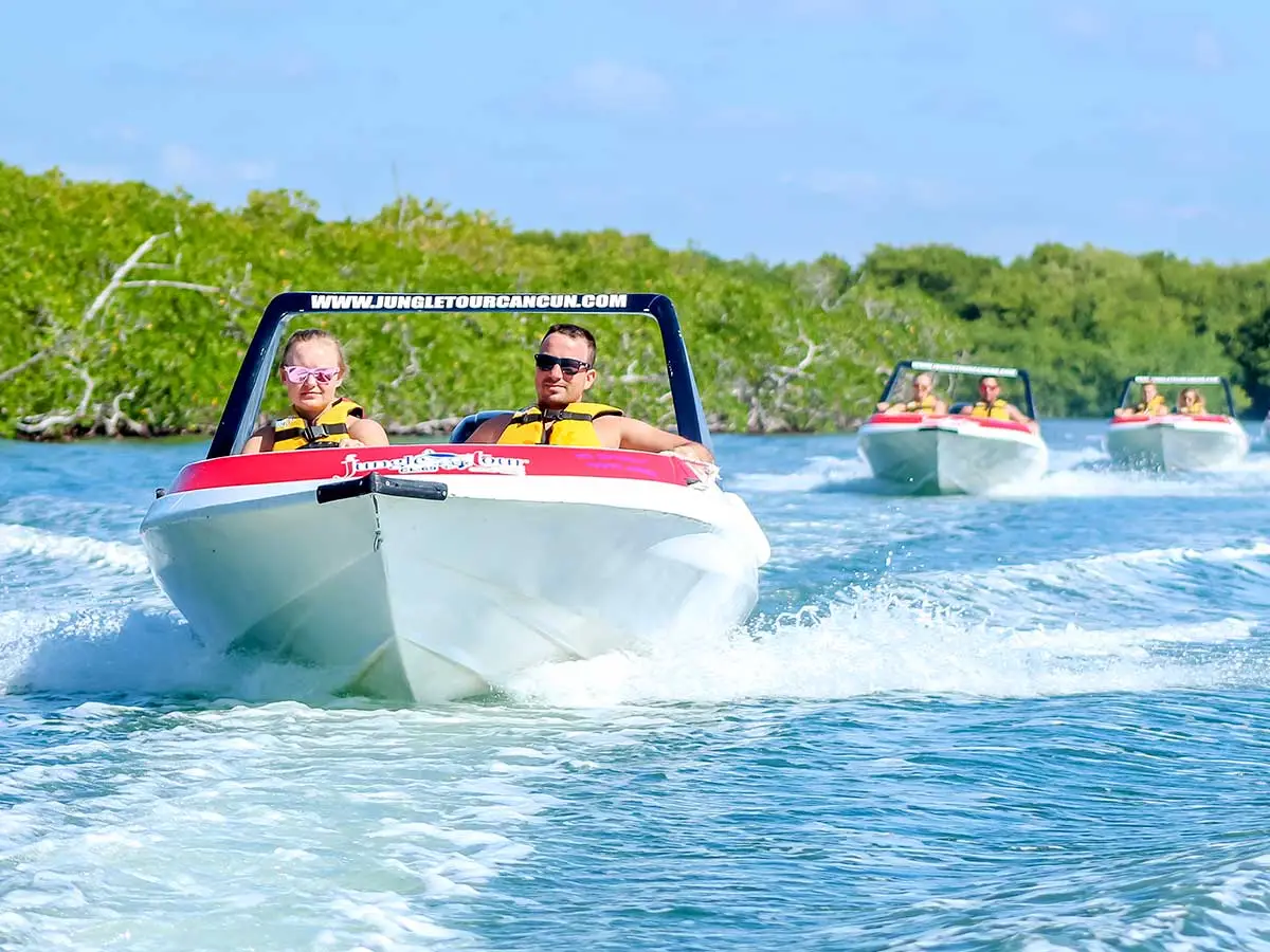 a caravan of three   speedboats sailing through the mangrove canals in Cancun