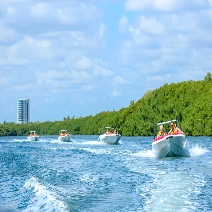 a woman driving a Jungle Tour Adventure speedboat, forming a caravan of four speedboats through the channels of the lagoon.